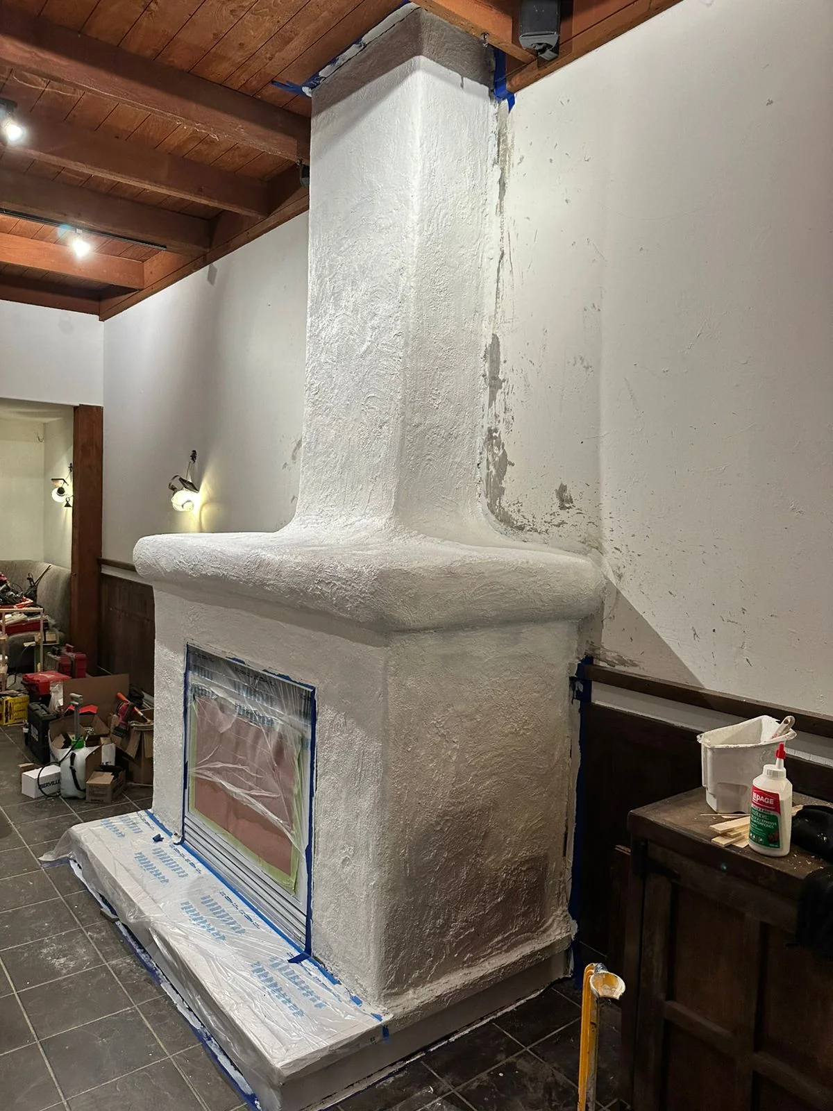 Custom restaurant fireplace receiving its hand-applied finish coat